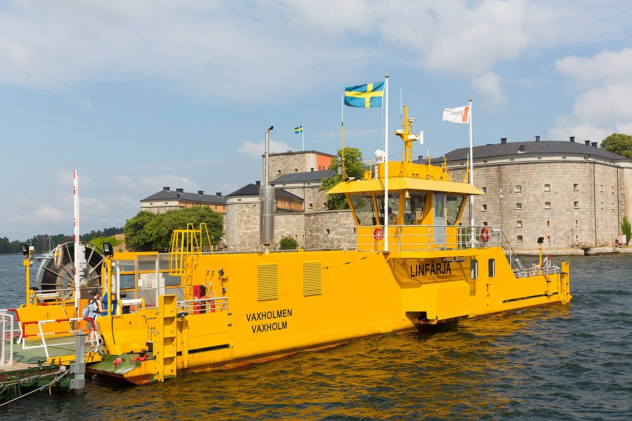 The yellow Vaxholm cable ferry in front of Vaxholm Fortress