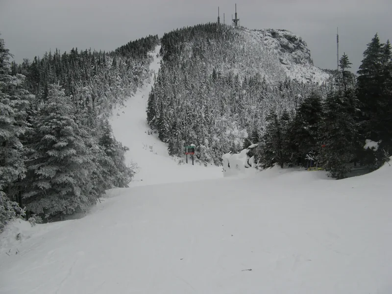 A snow-covered trail near the summit of Mount Mansfield between frosted spruce trees