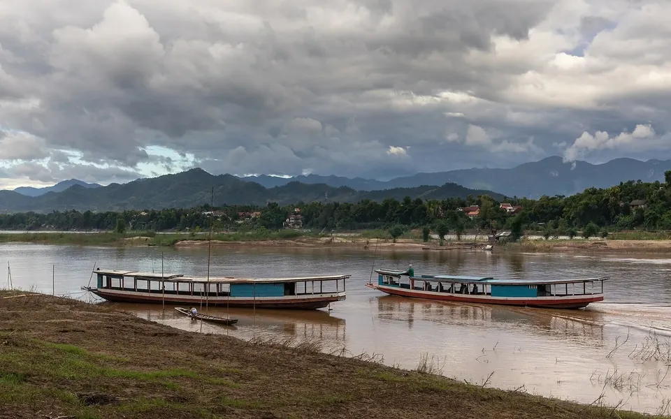 Long wooden slow boats moored on the Mekong River in Laos