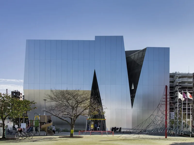 The angular silver-paneled building of the Sumida Hokusai Museum in Ryogoku under a blue sky