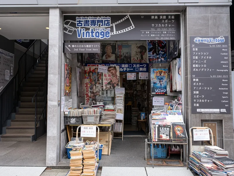 The front of a used bookstore in Jimbocho with stacks of books and magazines outside