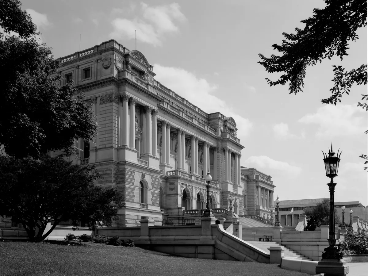 The Library of Congress Thomas Jefferson Building with its dome and a lamp post in front, in black and white