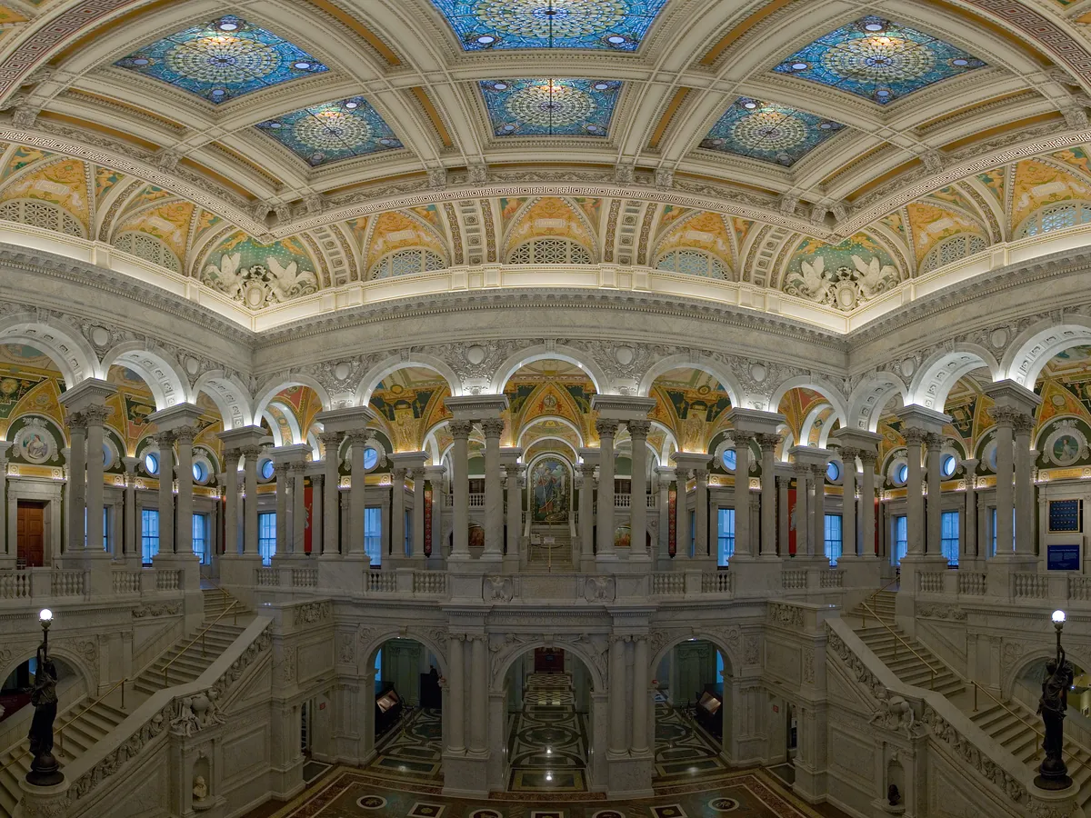 The Great Hall of the Library of Congress with marble columns, arches and a richly decorated, coffered ceiling